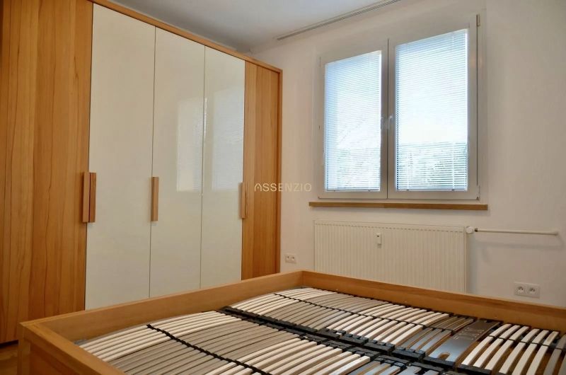 Hálószoba ággyal matrac nélkül, beépített szekrénnyel és ablakkal, 3 szobás lakás.