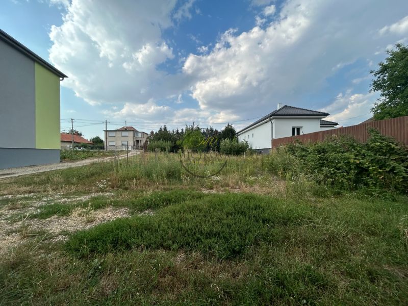 Kertek a telinci házak körül, változó felhőzet az égen.