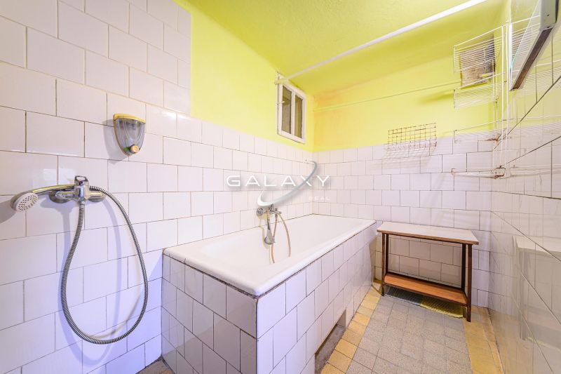 Fürdőszoba káddal és fehér csempével egy családi házban.
