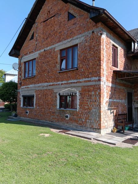 Családi ház Ovčiarske településen vakolatlan téglafalú homlokzattal és zöld gyepes telkekkel - lakóhely.