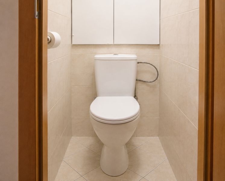 Fürdőszoba kétszobás lakásban bézs csempével és WC-vel.