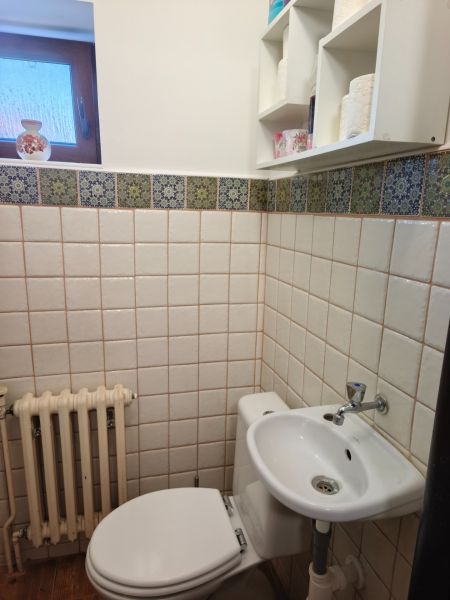 Fürdőszoba családi házban WC-vel, mosdóval és ablakkal, csempézett.