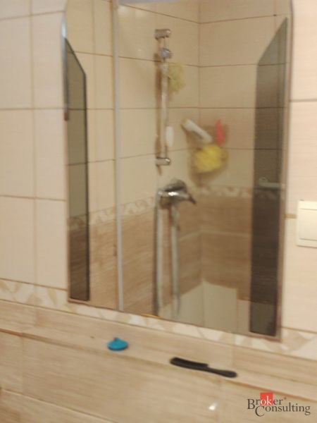 Folyosó egy családi házban fa dekoros padlóval és fekete ajtókkal.