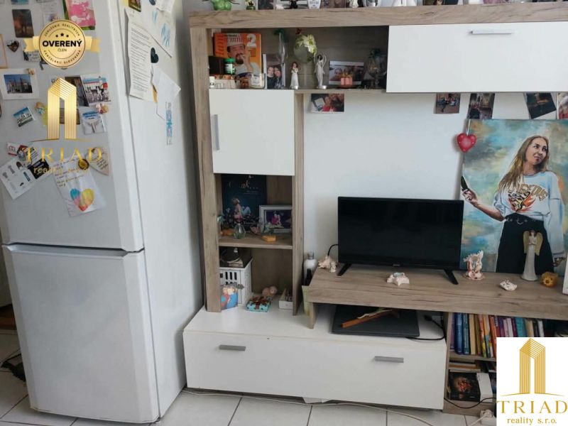 Nappali egy egyszobás lakásban fehér bútorokkal és dekorációkkal.