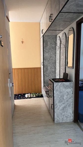 Keskeny folyosó fa dekor padlóval és praktikus tárolóhellyel.