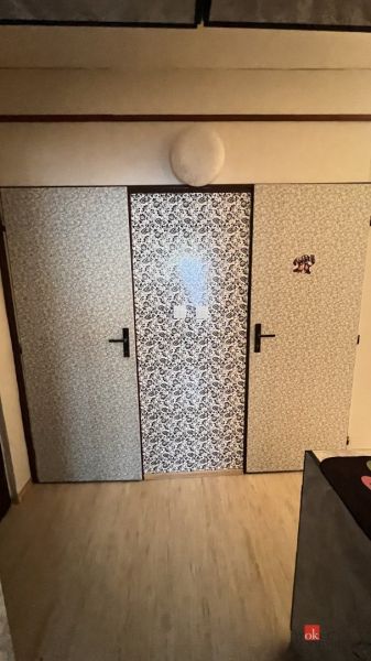 Tapétázott ajtók egy kétszobás lakás belsejében, fa dekoros padlóval.