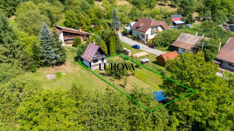 A Dubkova utcai ház Lazy pod Makytou-ban zölddel és más házakkal körülvéve.