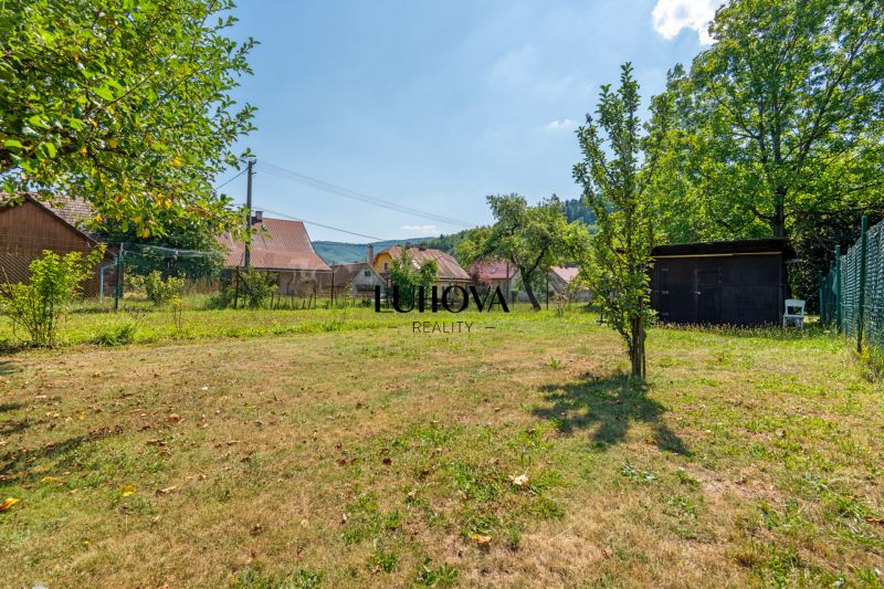 A Dubková utcai ház kertje Lazy pod Makytou-ban, amelyet természet és házak vesznek körül.