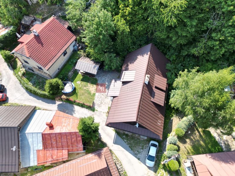 Légi felvétel egy házról a Besztercebánya melletti Szepesbányán, amelyet zöldterület és házak vesznek körül.