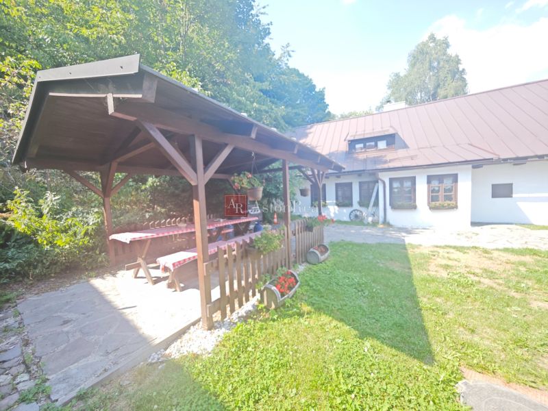 Házikó Špania Dolinában pavilonnal, faasztallal és virágdíszítéssel a kertben.
