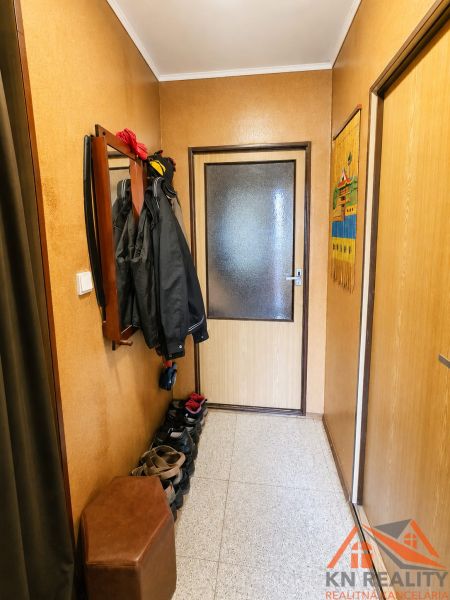 Családi ház folyosója ruhafogassal és cipősszekrénnyel, semleges árnyalatok.