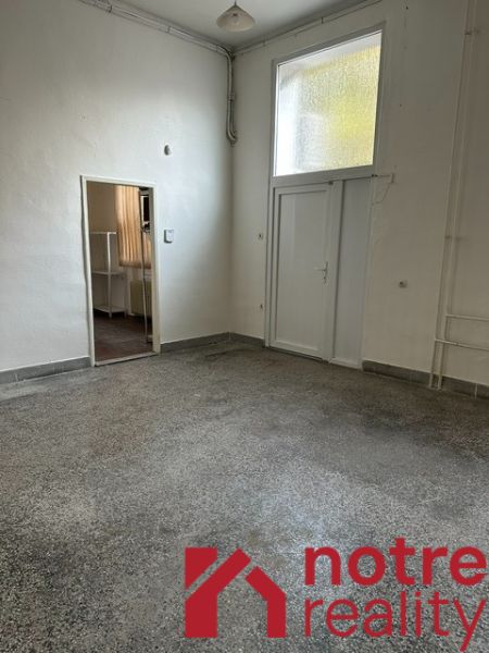 Iroda belső tér fehér falakkal és betonhatású padlóval.