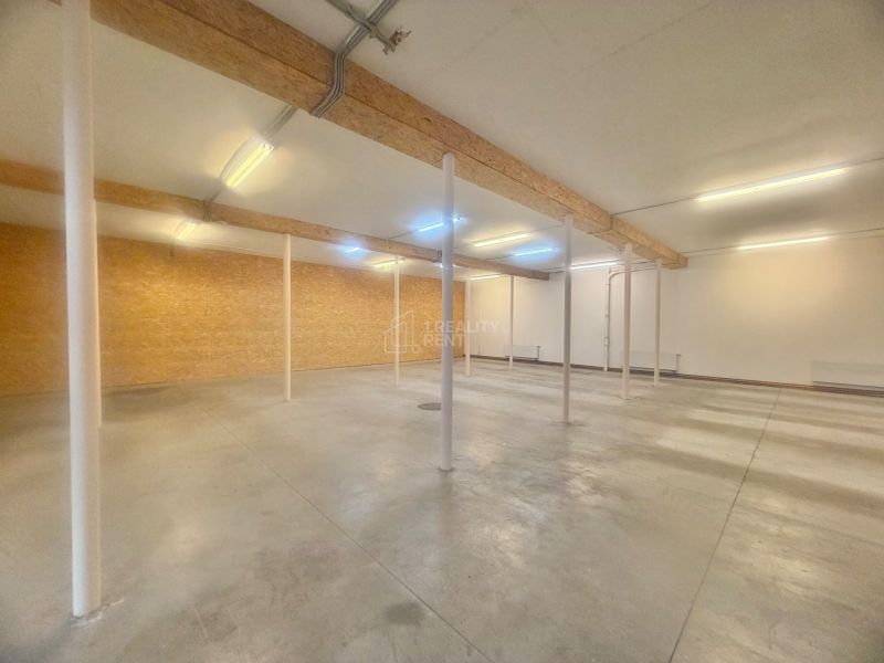 Nyitott terű üzlethelyiségek látható tartógerendákkal.