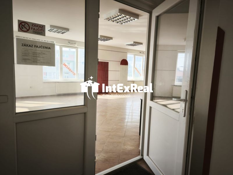 Üzlethelyiség belső tér kerámia padlóval és „Dohányozni tilos” feliratú tábla.