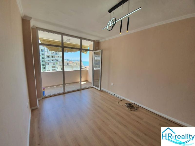 Rekreációs apartman üvegfallal és fa dekorációjú padlóval, erkéllyel.