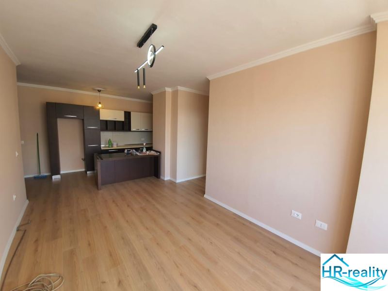 Nappali tér konyhasarokkal és fa dekoros padlóval a Nyaraló apartmanban.