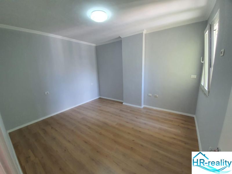 Világos szoba fa mintázatú padlóval a Nyaraló apartmanban.