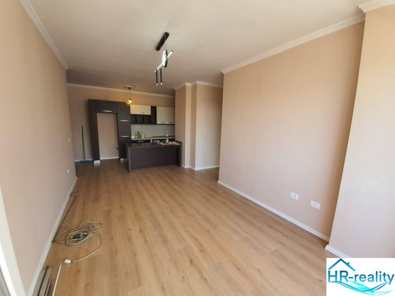 Konyha a nyaraló apartmanban fa dekor padlóval és finom színekkel a falakon.