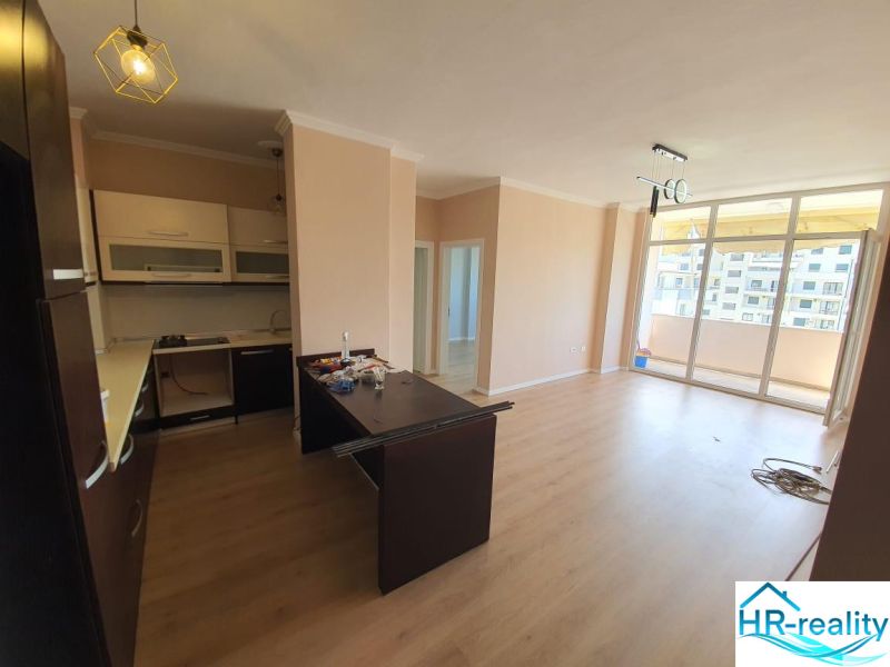 Konyha és nappali a nyaraló apartmanban, fa dekorációjú padló, erkély.