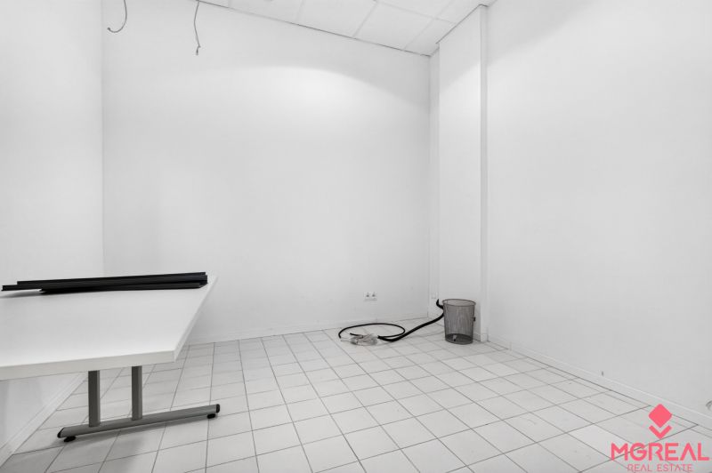 Üres belső tér fehér falakkal, asztallal és fehér csempével kereskedelmi helyiségben.