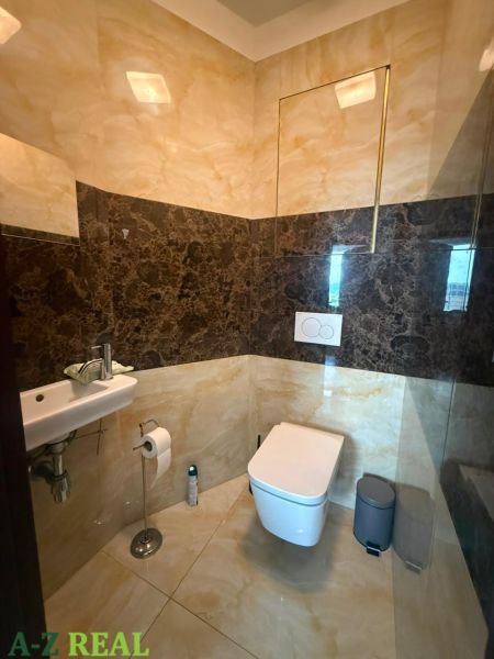 WC mosdóval a háromszobás lakásban, kőburkolat és padló.