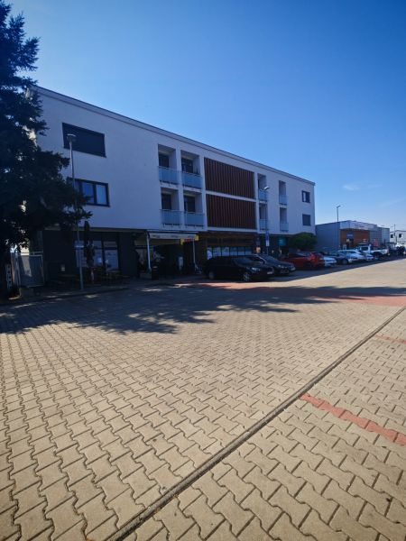 Épület a Senická utcában, Rohožníkban, parkolóhelyekkel az előtérben.