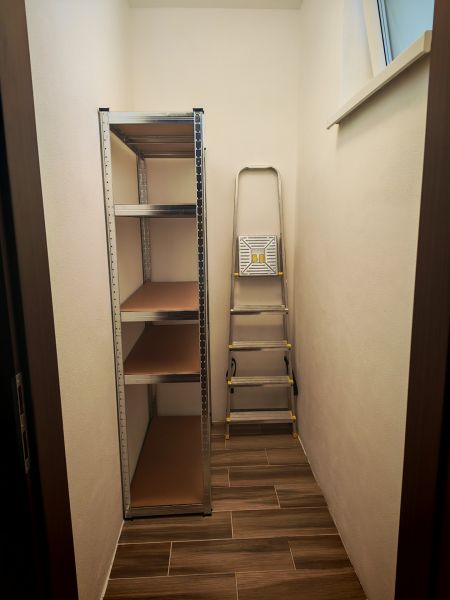 Tárolóhely egy kétszobás lakásban polcrendszerrel és létrával.