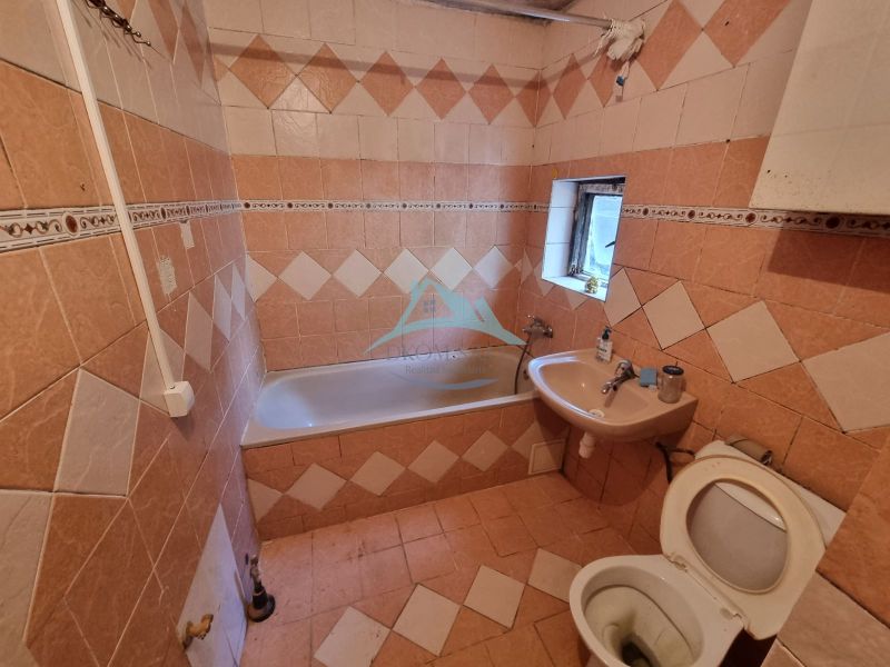 Fürdőszoba csempével és burkolattal, kád, mosdó és WC családi házban.