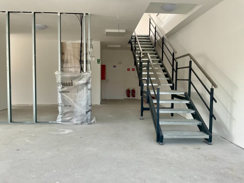 Lépcsőházi belső tér raktárakban és csarnokokban fémkorláttal és tartógerendával.