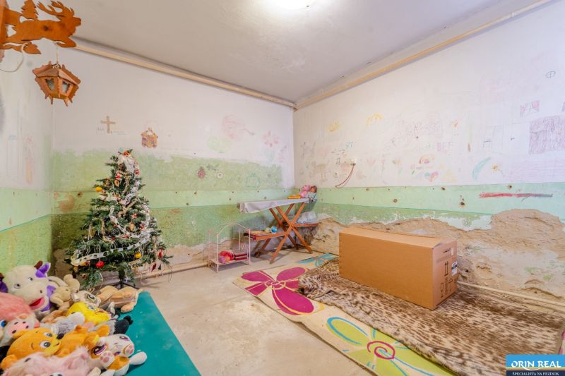 Gyerekszoba díszített karácsonyfával, rajzokkal a falakon és plüss játékokkal a családi házban.