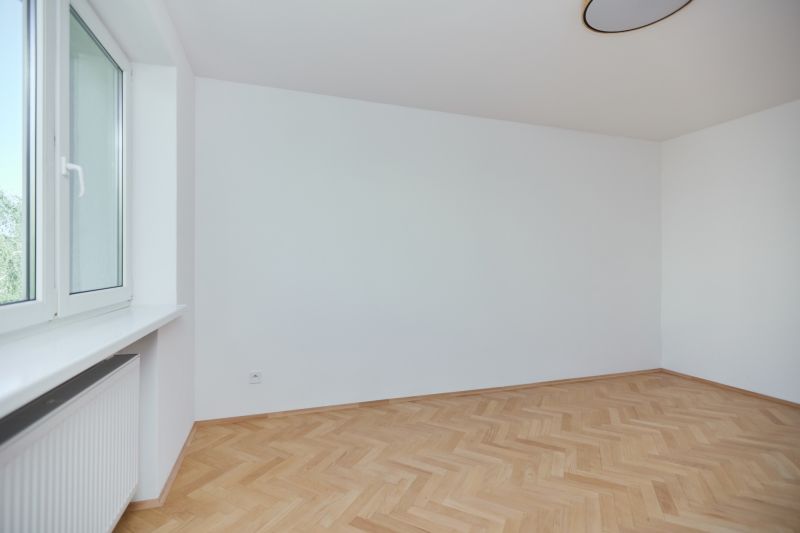 Üres szoba fa hatású padlóval egy háromszobás lakásban.