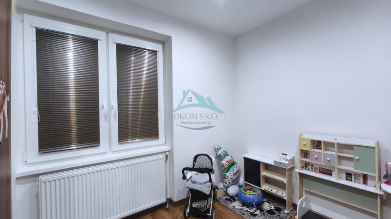 Gyerekszoba családi házban játékokkal, babakocsival és fa dekorú padlóval.