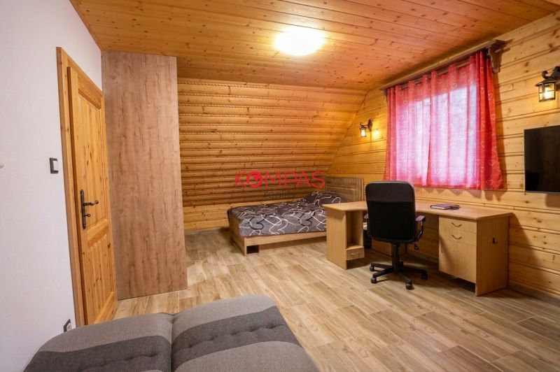 Egy szoba családi házban, fa falakkal, fa dekoros padlóval és íróasztallal.
