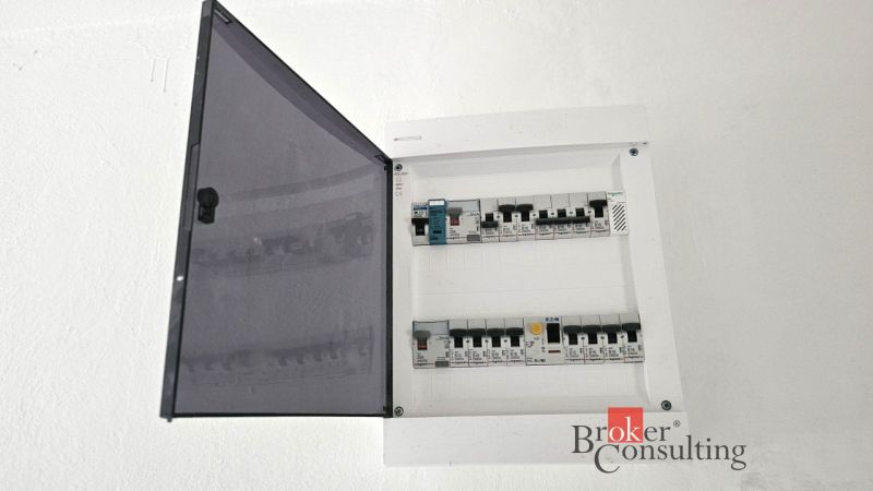 Négy szobás lakás elektromos elosztószekrénye nyitott biztosítékokkal.