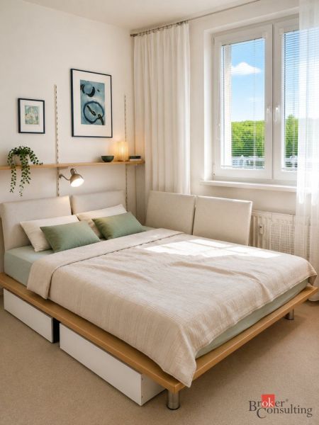 Hálószoba ággyal, két párnával, minimalista dekorációval egy kétszobás lakásban.