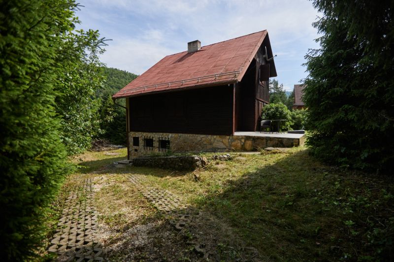 A Jaklovce-i Rovná utca 61. szám alatti ház, amelyet zöld növényzet és fák vesznek körül.