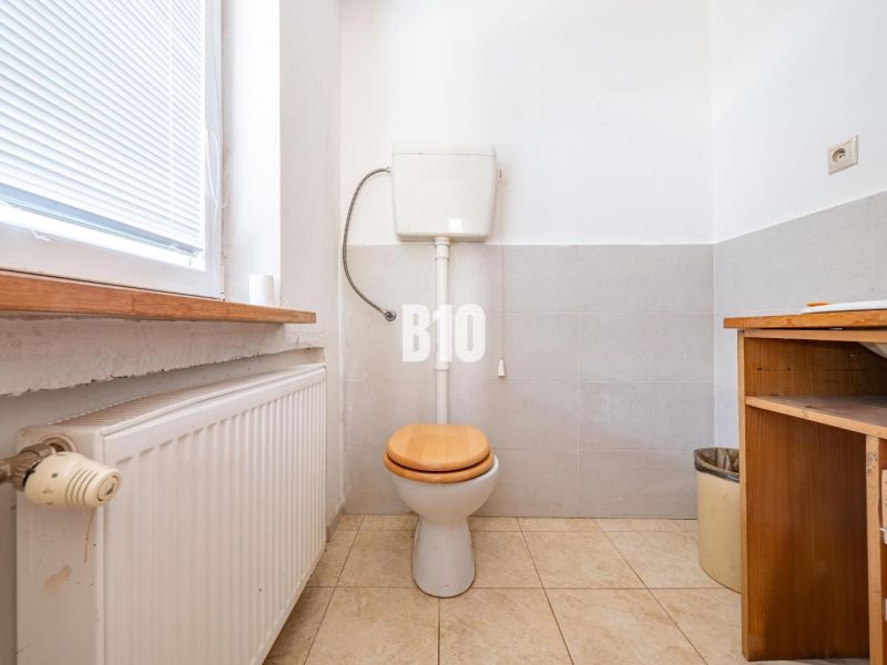 WC ablakkal, radiátorral és tárolóhellyel a családi házban.