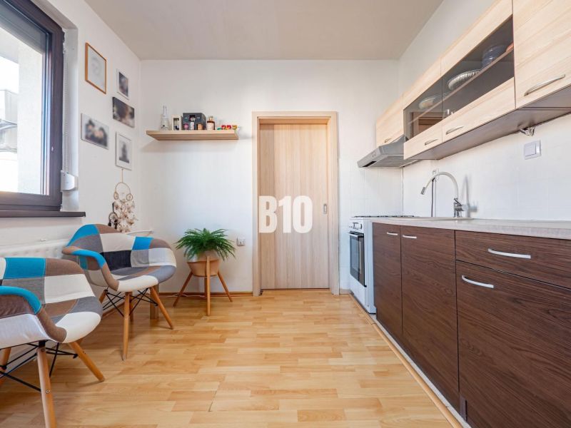 Konyha egy egyszobás lakásban fa dekor padlóval és modern bútorokkal.