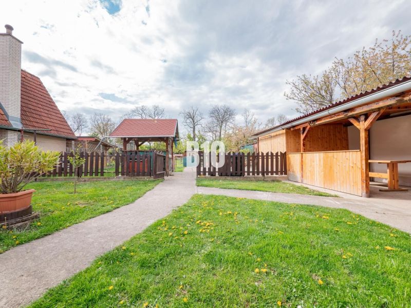 Nyitra, családi ház, kert fa pavilonnal, járdával és kerítéssel.