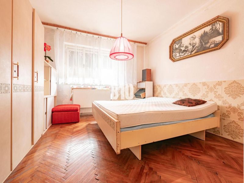 Hálószoba családi házban, fa dekorációjú padlóval és vintage kiegészítőkkel.