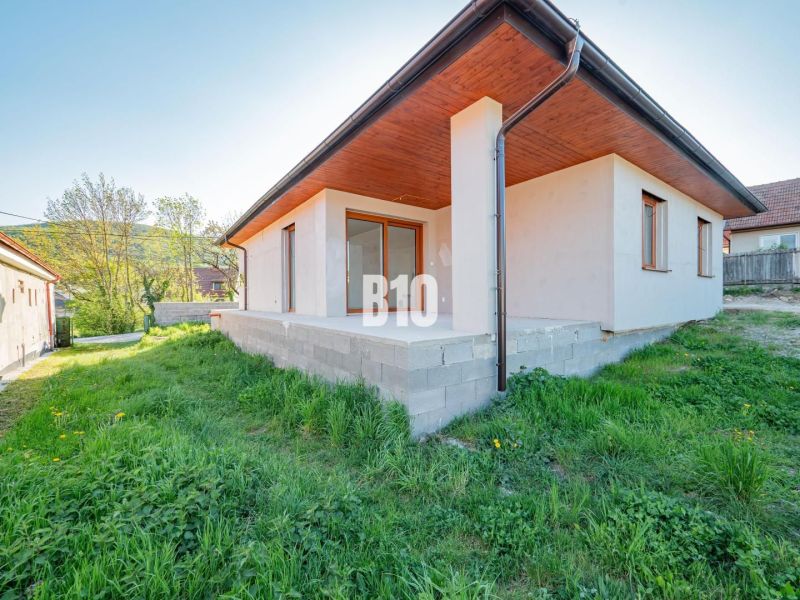 Családi ház Nyitrán beton terasszal és zöld gyepes kerttel.