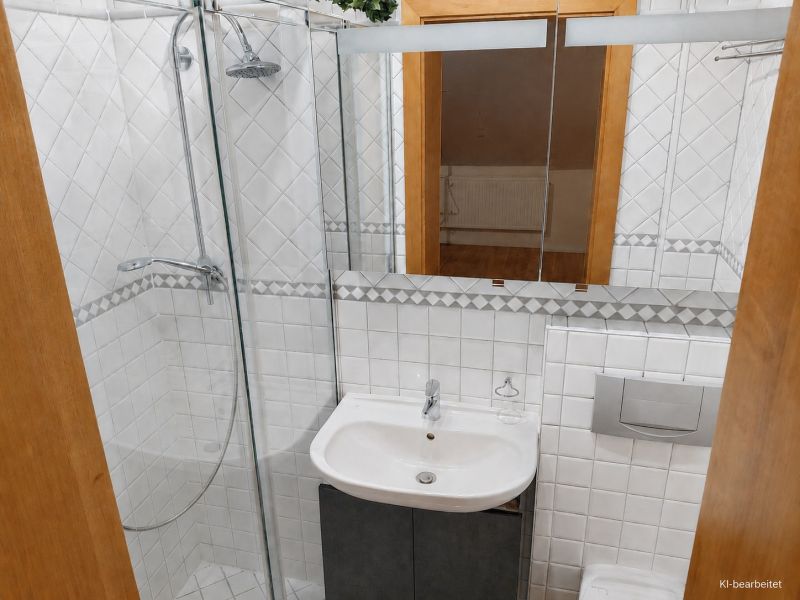 Fürdőszoba családi házban fehér csempékkel és zuhanyzóval.