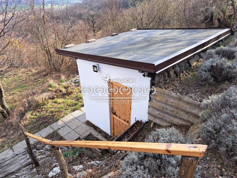 Kis házikó ferde tetővel Dolné Orešanyban, a dombos Dolné Orešany utcában.