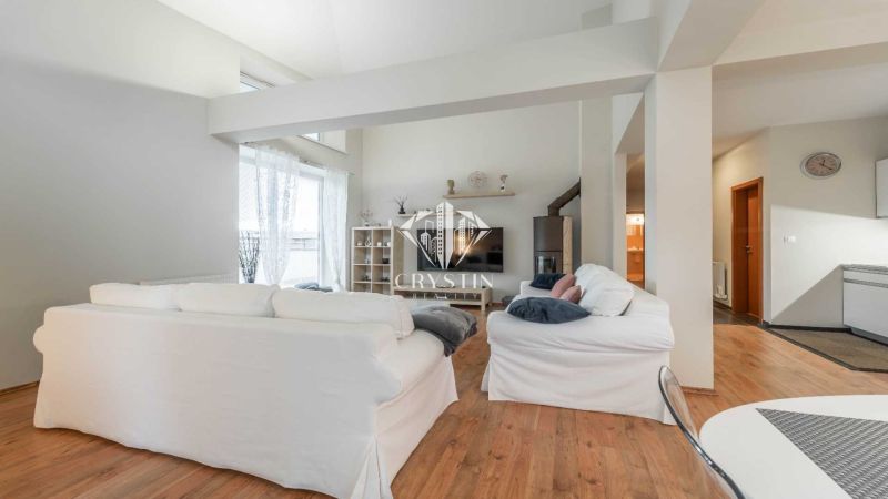 Nyaraló apartman fehér kanapékkal és fa dekorációjú padlóval, világos környezet.