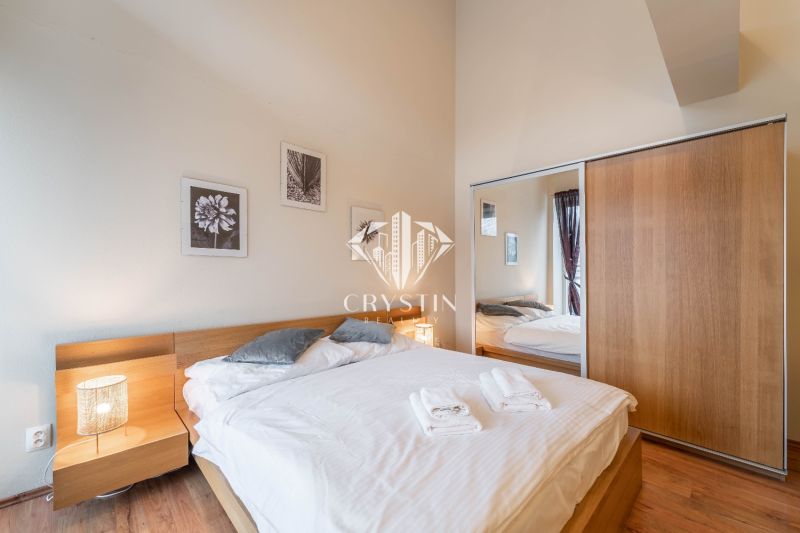 Hálószoba ággyal és fa dekorációjú padlóval egy üdülő apartmanban.
