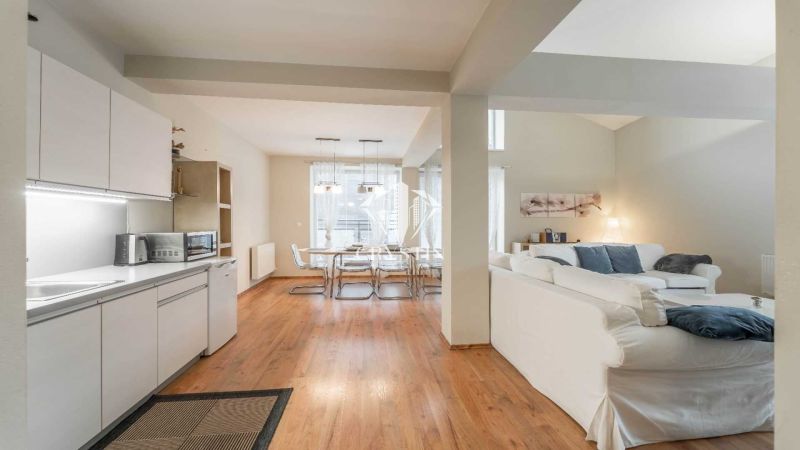 Rekreációs apartman fa dekorációjú padlóval, konyhával, étkezőasztallal és kényelmes ülőhellyel.
