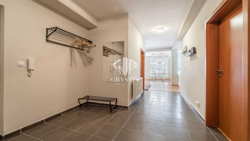 A rekreációs apartman folyosója járólappal, tükörrel és fogasfallal.
