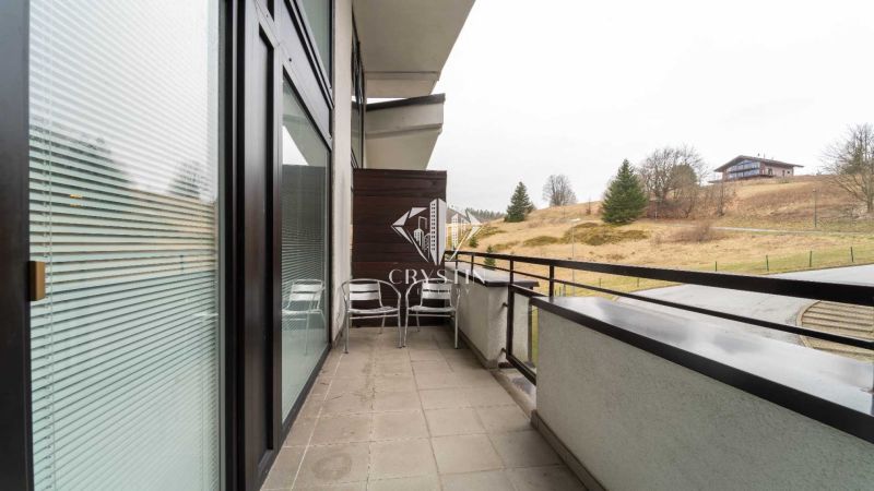 Rekreációs apartman erkélye Donovalyban, kilátással a természetre és a házakra.