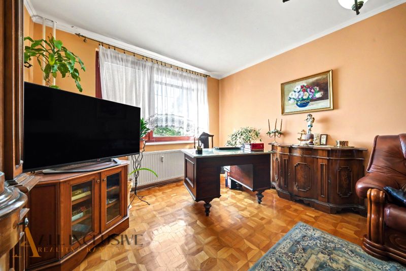 Dolgozószoba egy háromszobás lakásban, fa dekorációjú padlóval és fa bútorokkal.