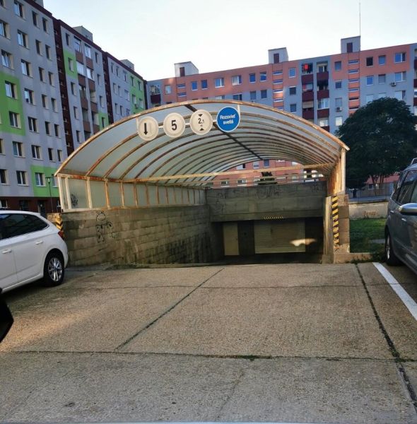 Garázsok a Rajecká utcában Pozsony - Vrakunán, lakóházak előtt autókkal.